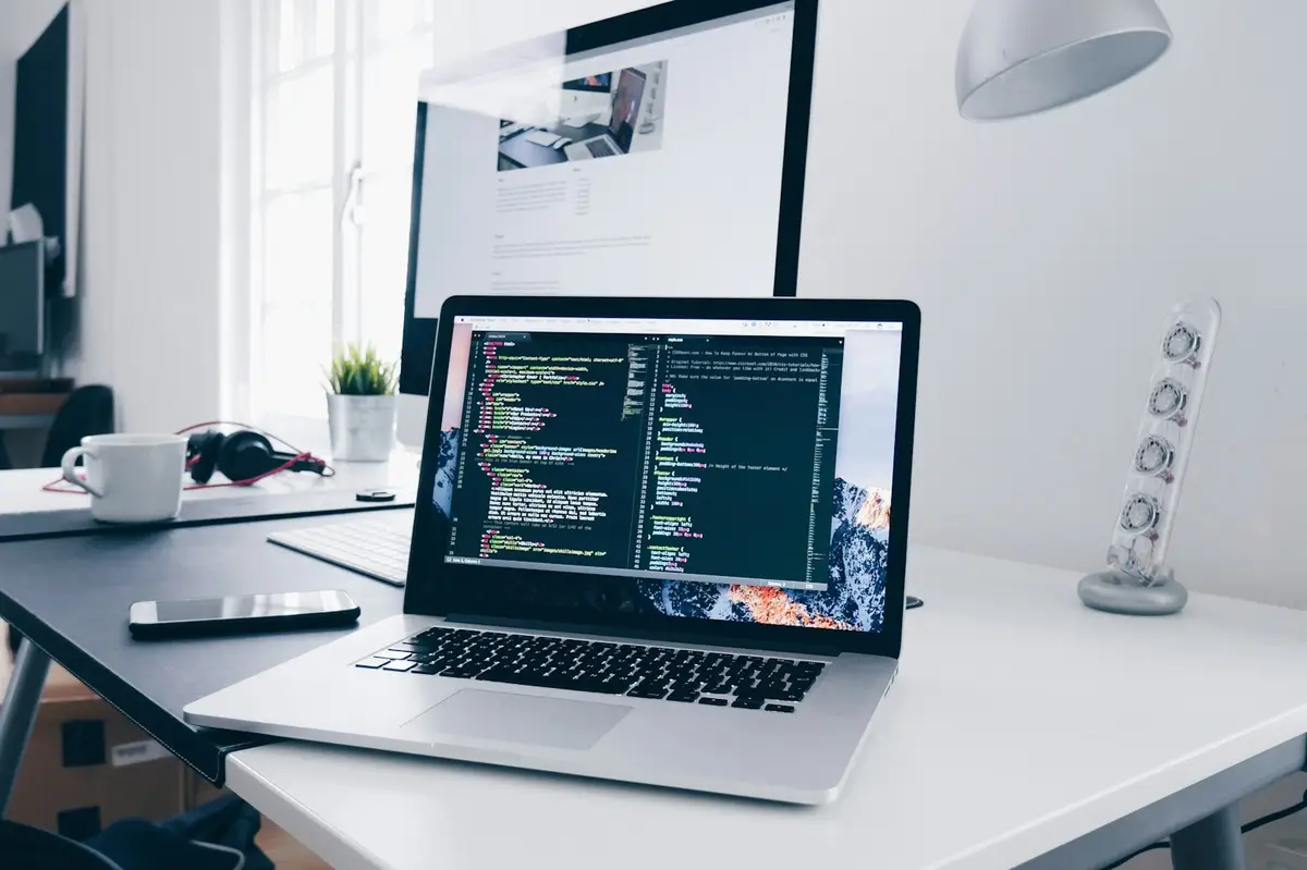 Laptop on a desk showing TypeScript source code for a Next.js application